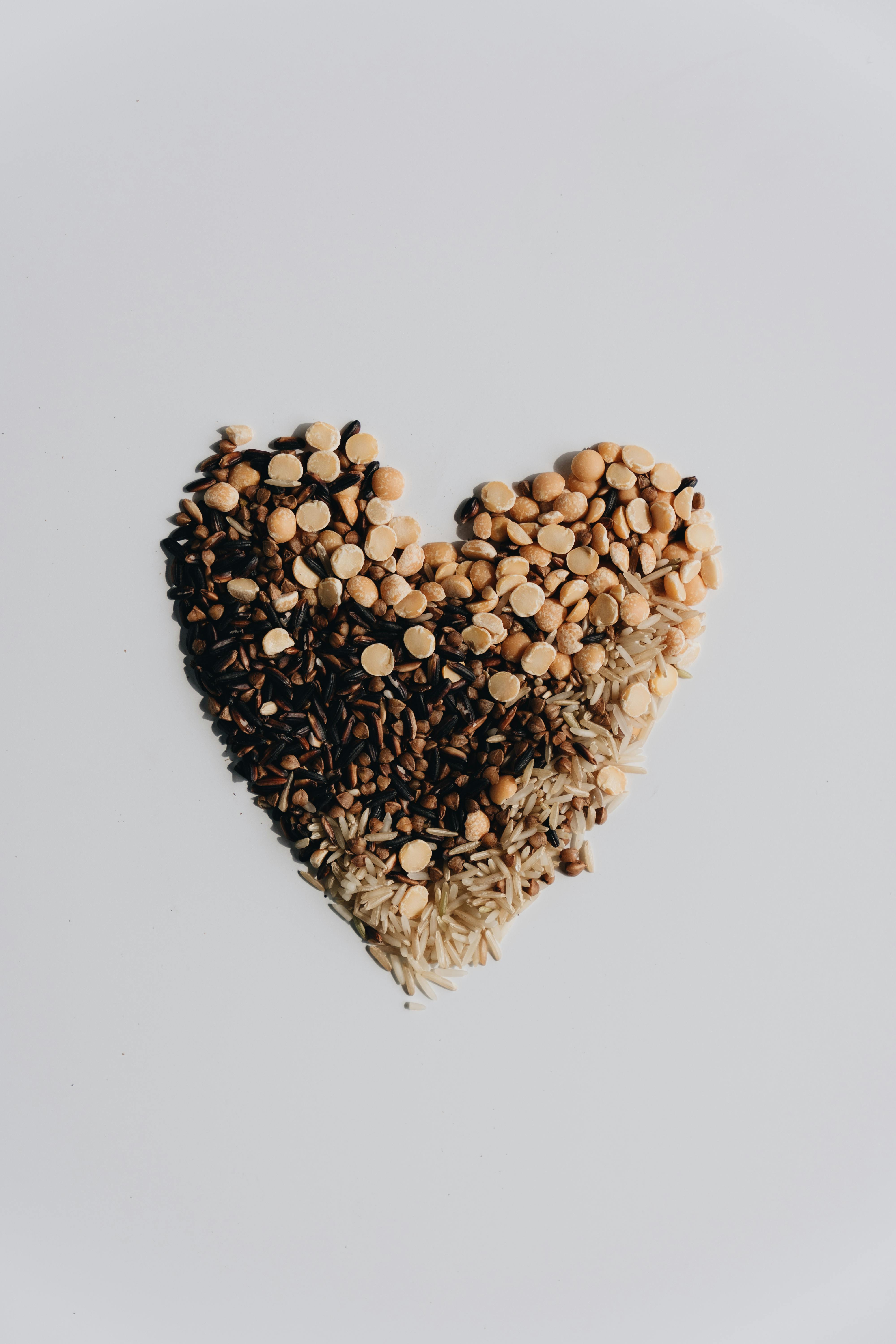A creative heart shape made from assorted grains on a white background.
