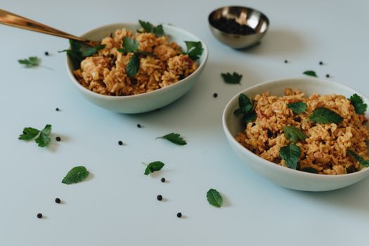 Delicious chicken biryani garnished with fresh herbs in stylish bowls. Perfect for food enthusiasts.