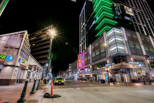 From below of contemporary illuminated towers along road at night in modern city district