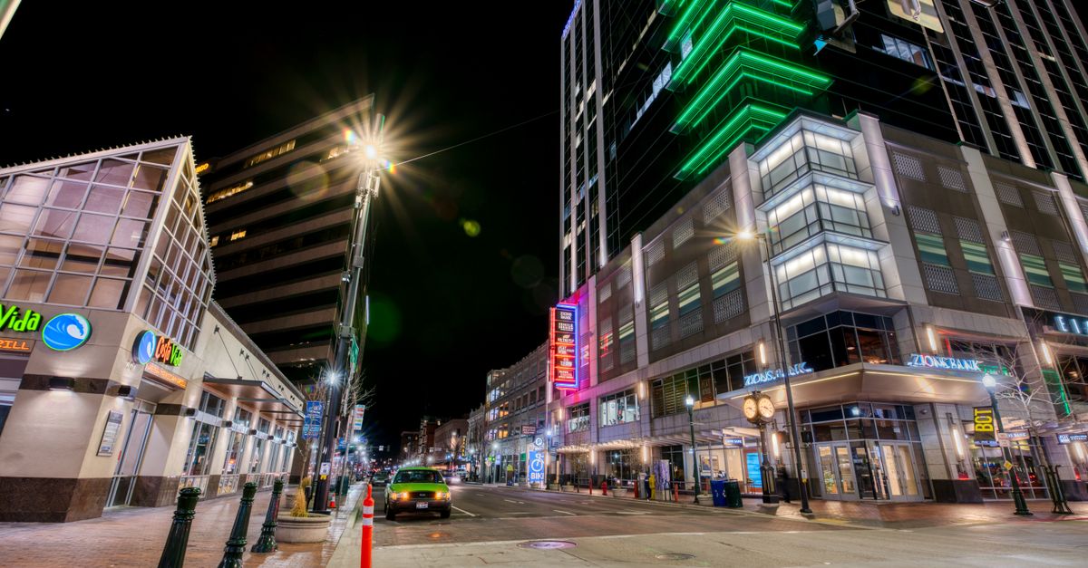 From below of contemporary illuminated towers along road at night in modern city district