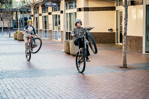 Cheerful teens riding bicycles on sidewalk