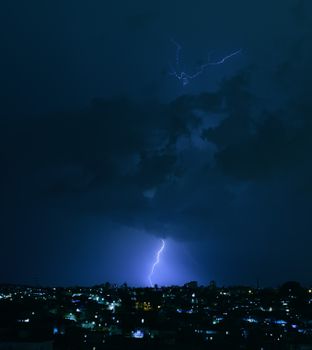 夜间雷暴时，闪电照亮了充满活力的城市景观