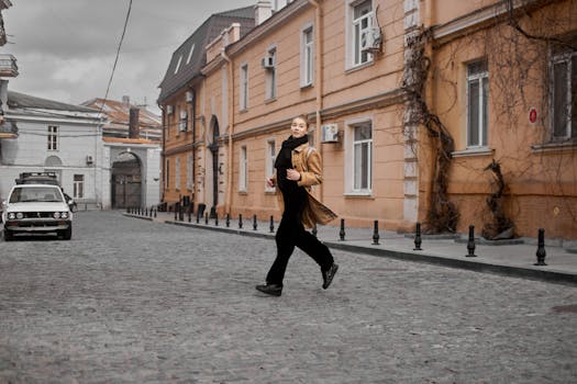 Full body side view of female wearing warm outerwear crossing street while running and looking away