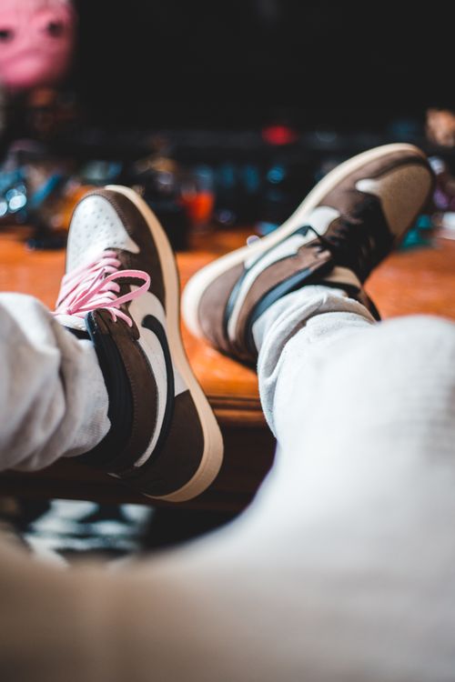 Free Crop anonymous male in new trendy sports boots sitting alone at comfortable home Stock Photo