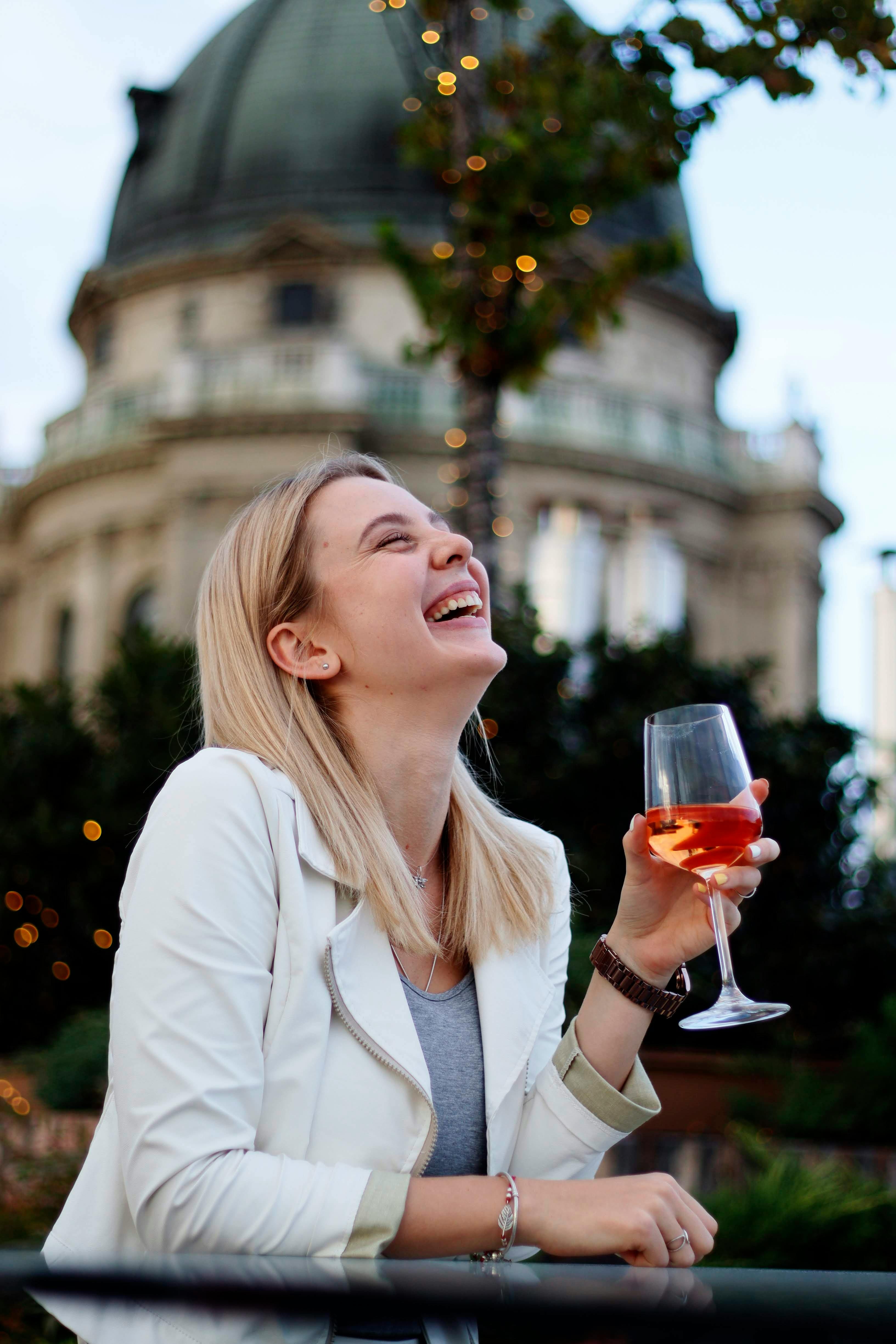 Mulher Rindo Bebendo Vinho Em Restaurante De Rua · Foto profissional gratuita