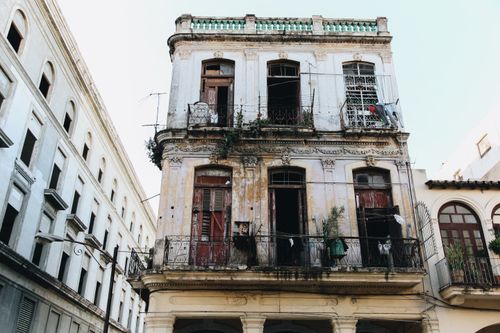 Free Weathered facade of an old residential building with balconies and windows. Stock Photo