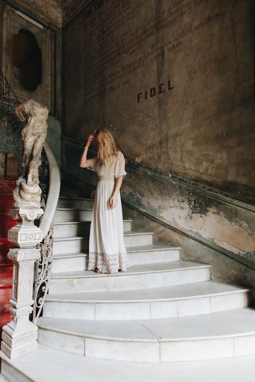 Free Woman in Dress on Stairs by Sculpture Stock Photo