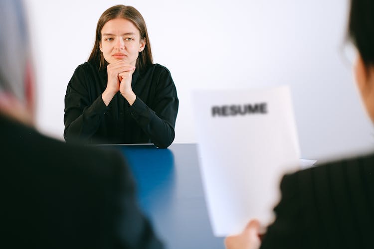 Woman In Black Long Sleeve Shirt Sitting Having Interview