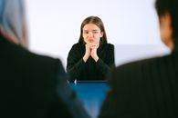 一名女性在求职面试中，全神贯注地面对着办公桌旁的两个人