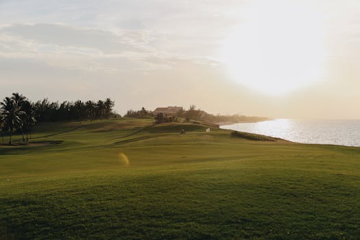 Beautiful sunset over a coastal golf course with lush green terrain.