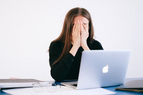 Free Woman With Hands on her Face in front of a Laptop Stock Photo