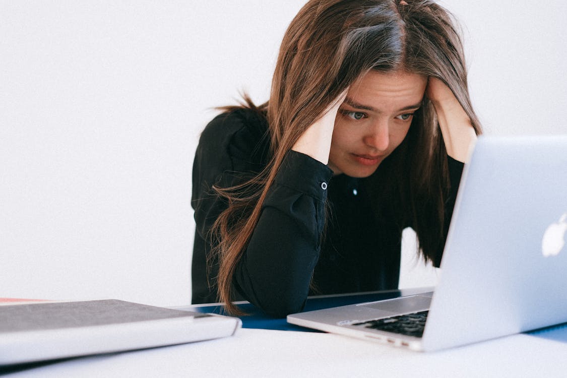 Zestresowana kobieta siedzi przed komputerem