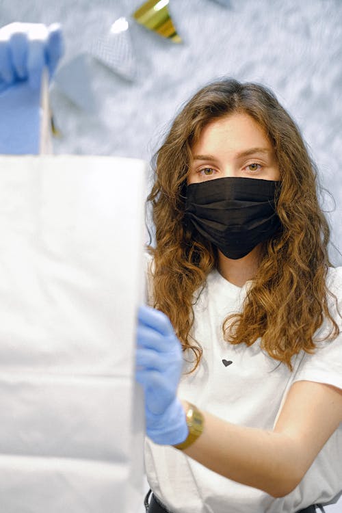 Woman With Face Mask and Latex Gloves Holding a Shopping Bag