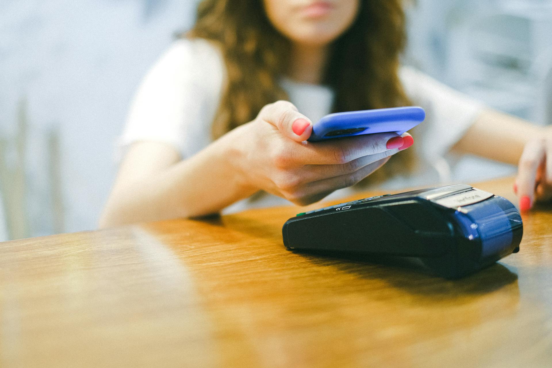 A Woman Paying Using Her Smartphone