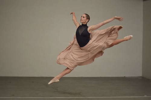 Muscular female dancer rehearsing in spacious studio