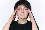 一位妆容鲜艳、戴着眼镜的女性特写肖像，散发着自信