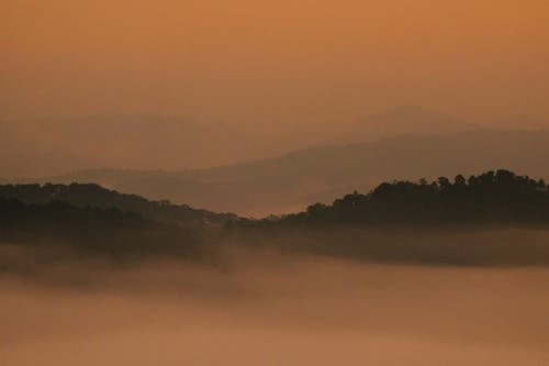 Silhouette of Mountains during Fog