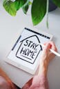 A Person Writing "Stay Home" at an Ipad using an Apple Pencil