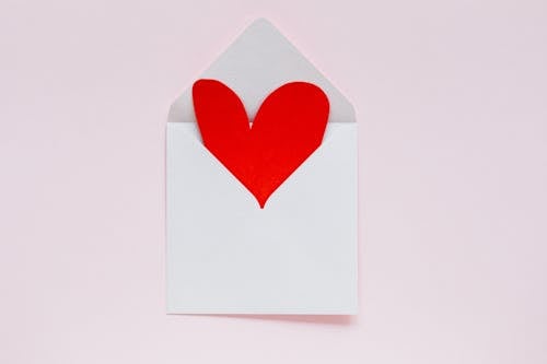 Open envelope with heart made of colored carton