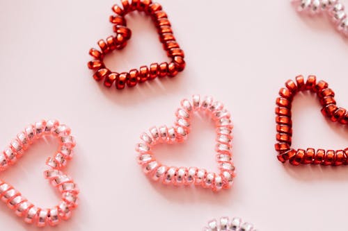 Free Colorful hair ties in shape of hearts on pink surface Stock Photo