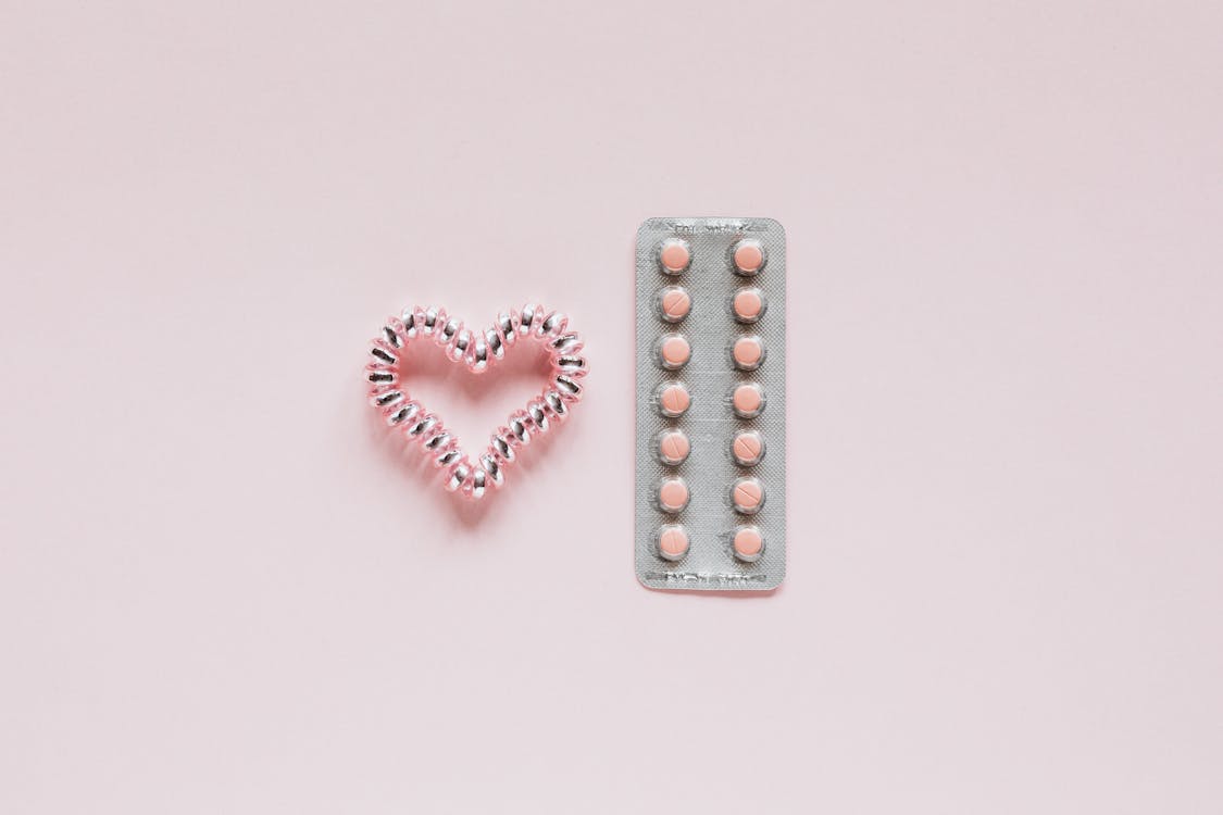 Glistening heart near packaging with pills