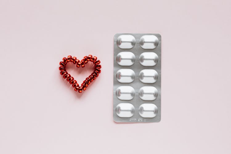 Set Of Blister With Pills And Heart On Pink Background