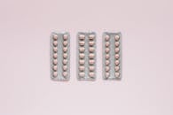 Set of various medical pills on pink background
