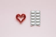 Composition of heart and pills on pink background