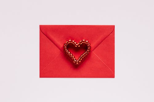 Free Colorful gift envelope with heart on pink background Stock Photo