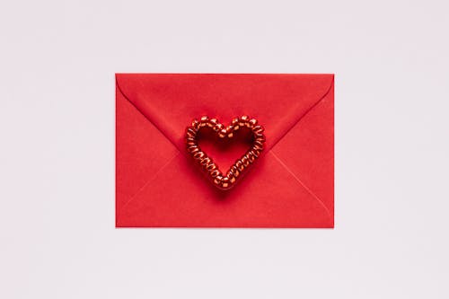 Colorful gift envelope with heart on pink background