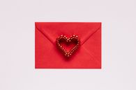 Colorful gift envelope with heart on pink background
