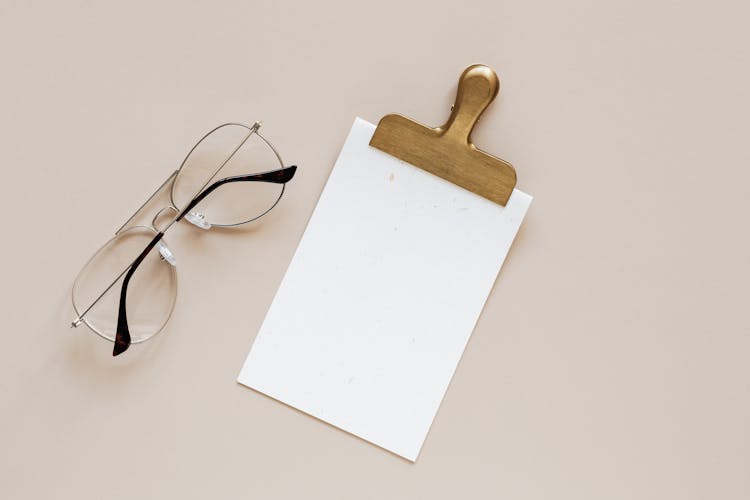 Composition Of Glasses And Clip On Beige Background