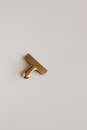 Top view of golden paper clip placed on beige surface
