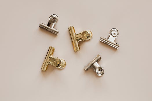 一张在米色背景上展示金属金和银夹的极简主义头顶照片