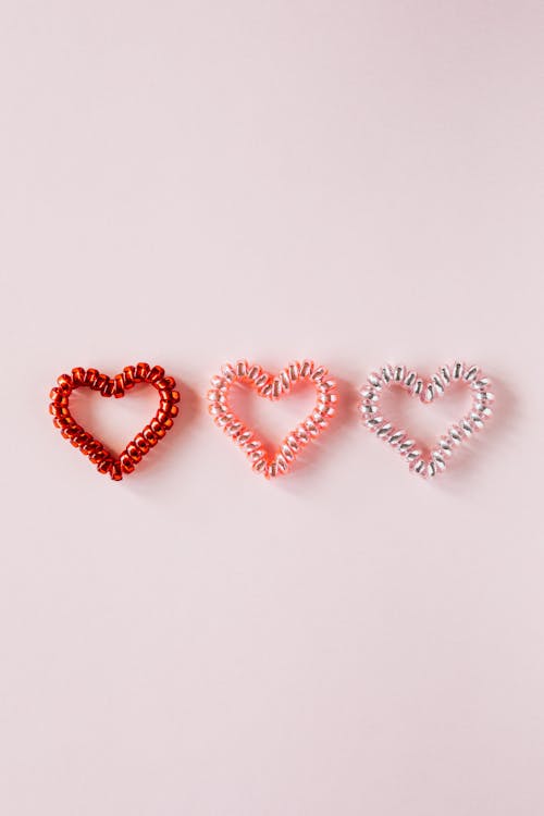 Free Different hearts on pale pink surface Stock Photo