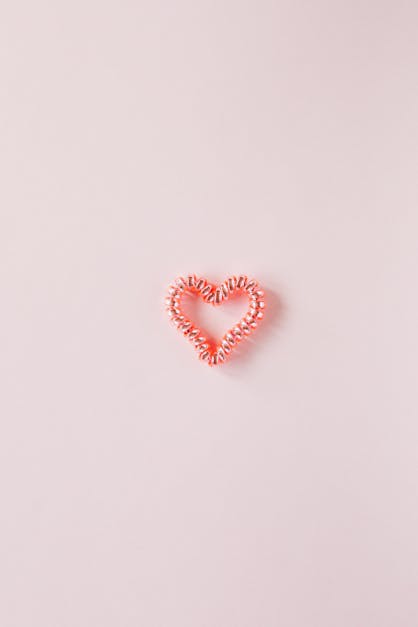 Small decorative heart on smooth pink surface · Free Stock Photo