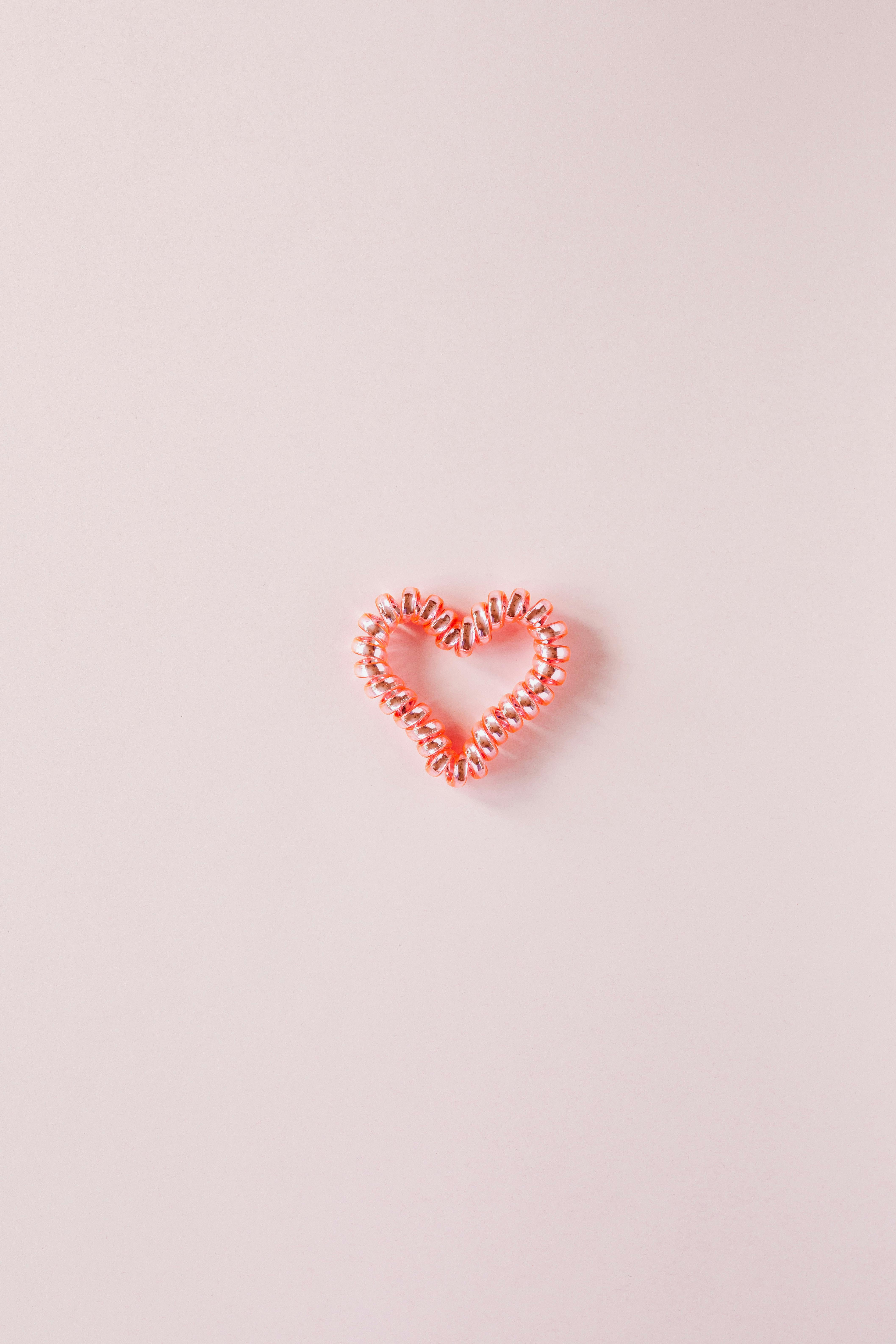 Small decorative heart on smooth pink surface · Free Stock Photo