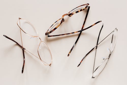 Free From above of fashion glasses with optical lenses for vision correction in metal shells together with pair in plastic tortoise shell placed on white table Stock Photo
