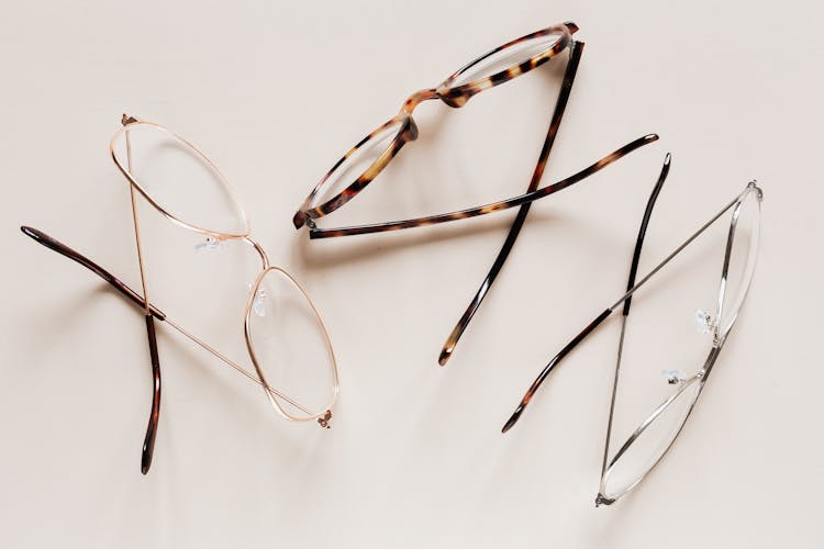 Stylish Eyeglasses Arranged On White Desk