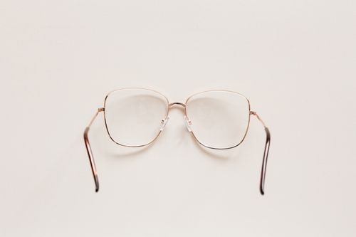 Free Top view of fashion spectacles with transparent optical lenses in golden metal shell placed on white table Stock Photo