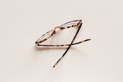 Stylish eyeglasses placed on beige surface