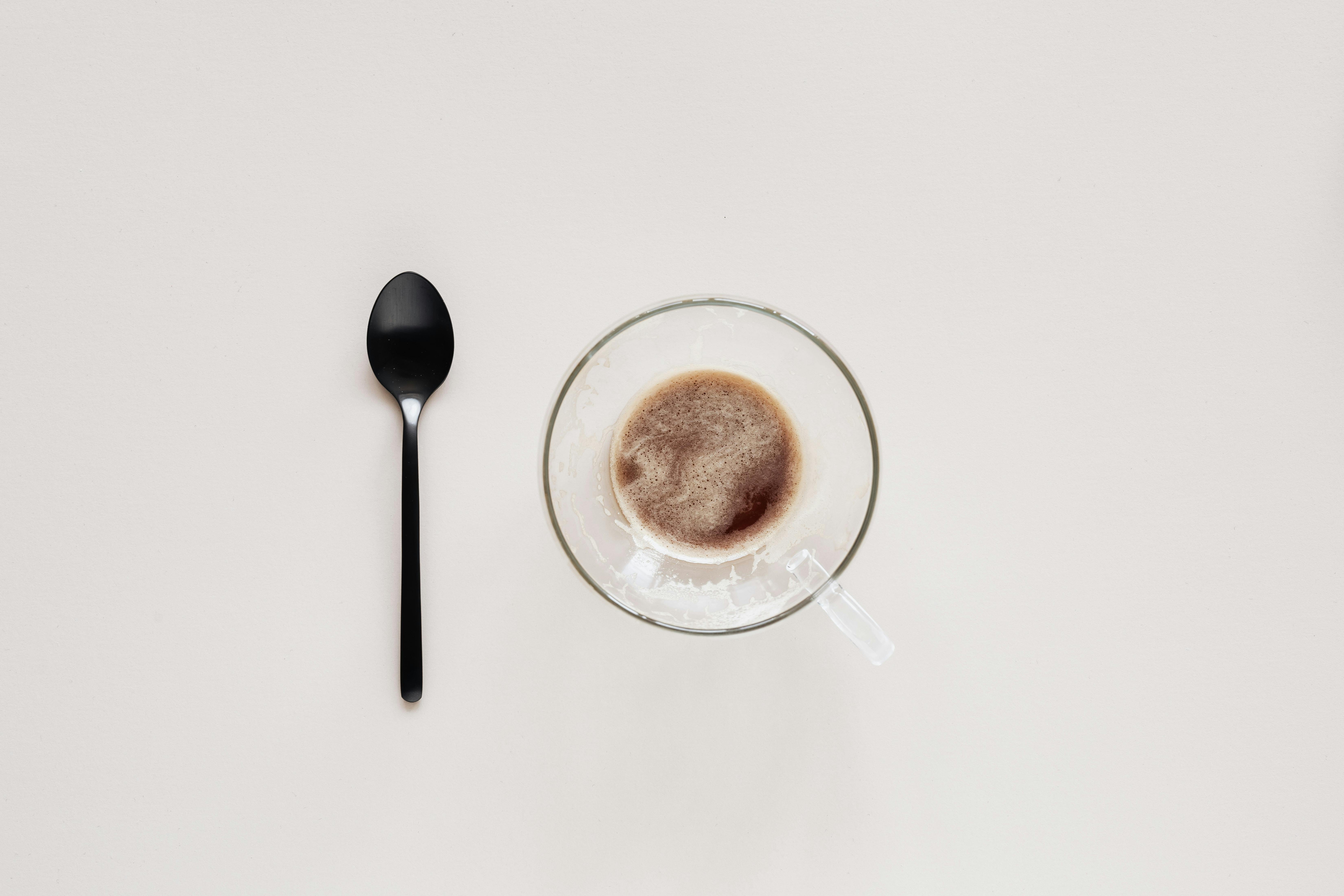 cup of coffee and teaspoon on beige background