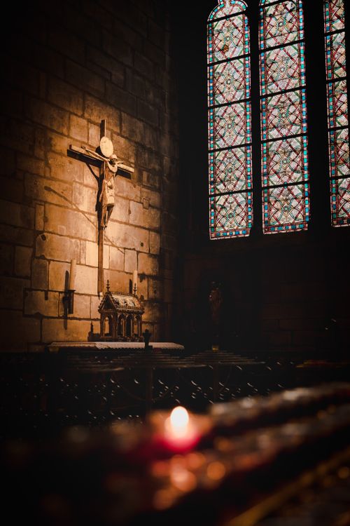 Free Atmospheric Gothic church interior with illuminated altar and stained glass window in Paris, France. Stock Photo