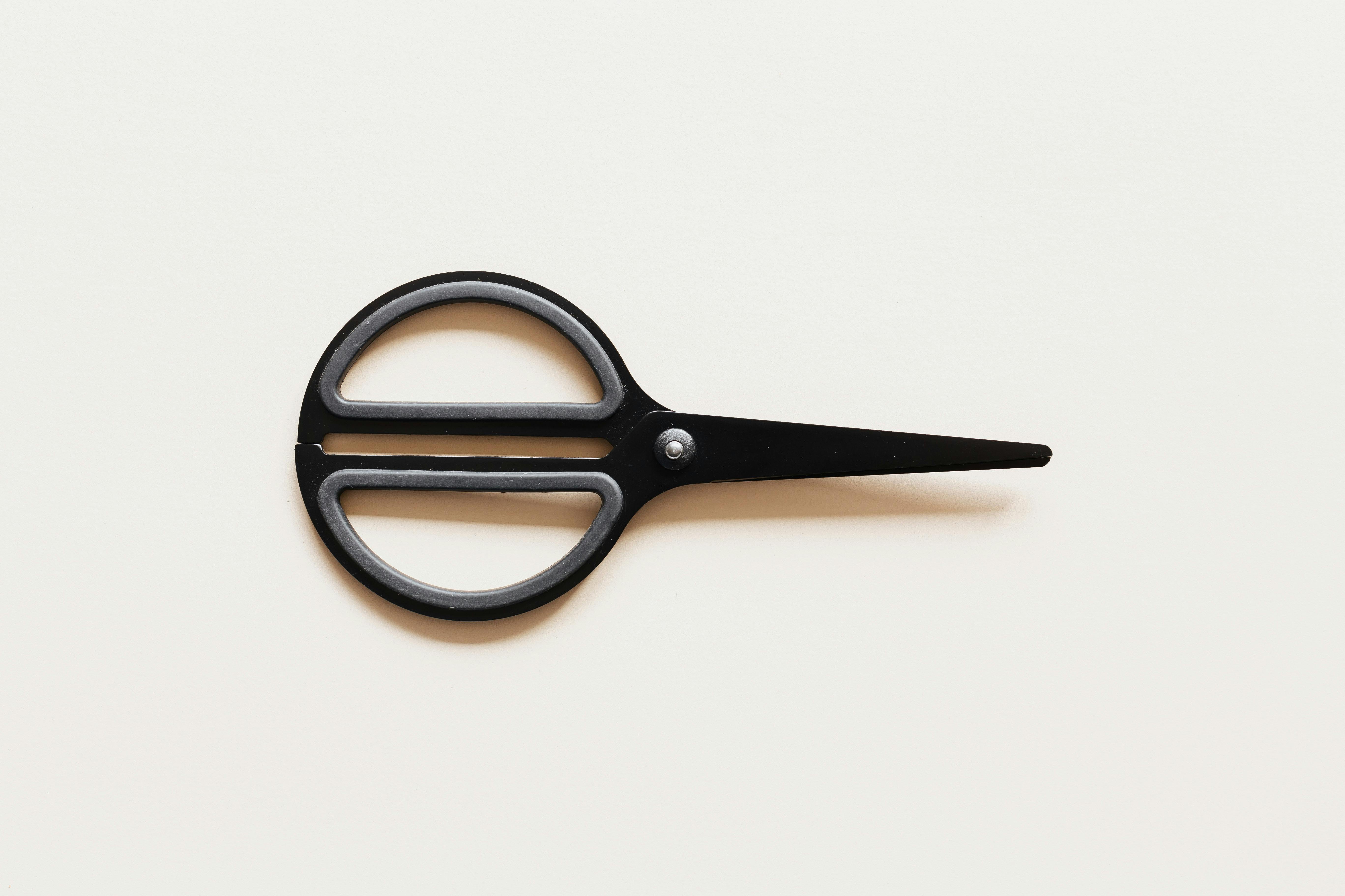 Small scissors placed on beige background · Free Stock Photo