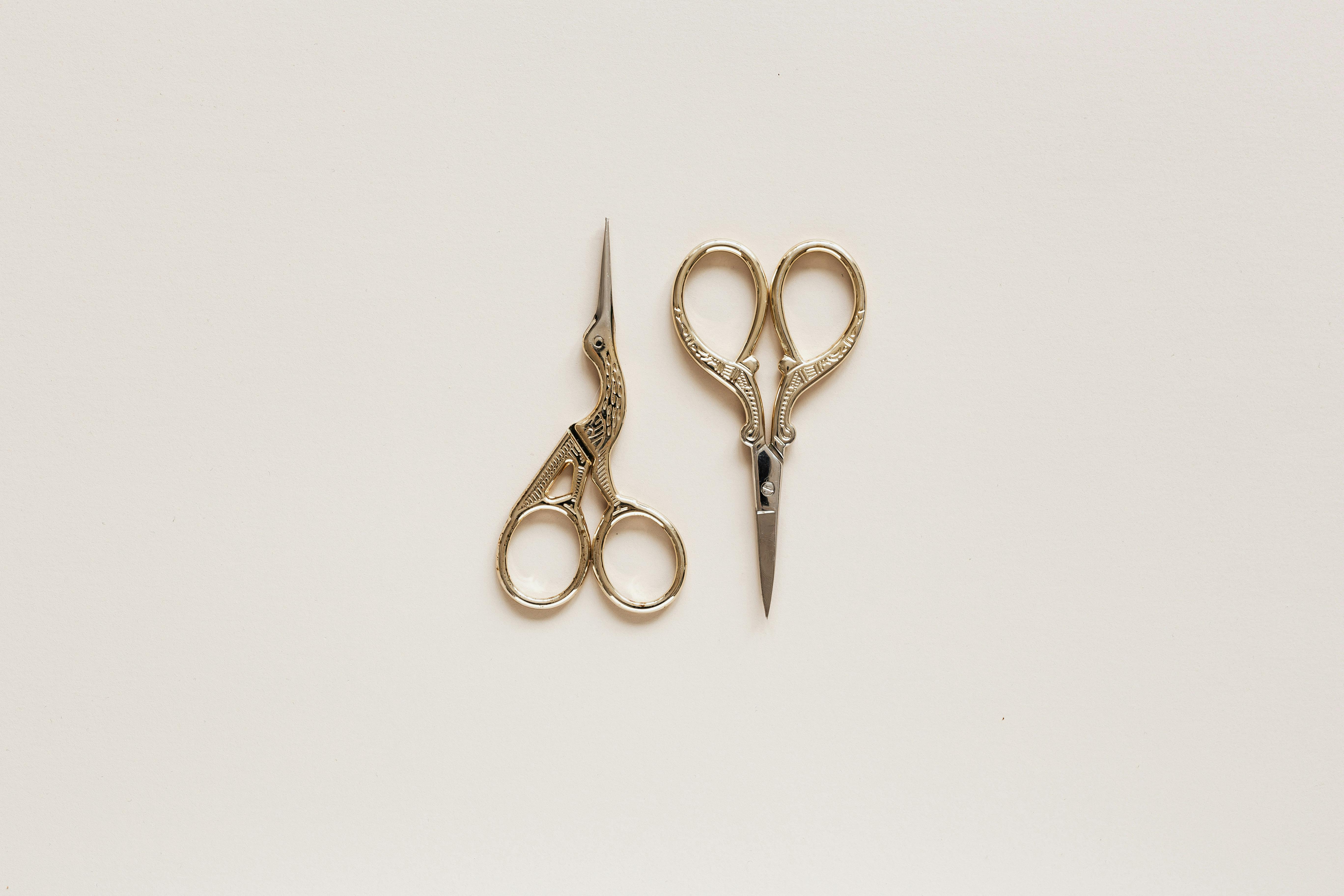 small golden scissors on beige surface