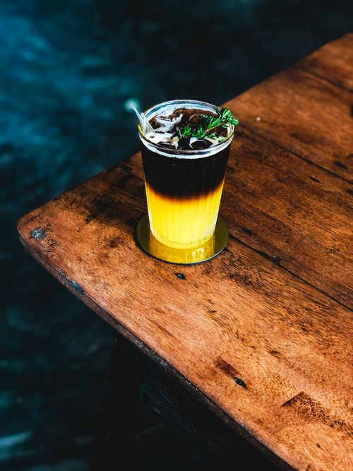 Free High angle of transparent glass of alcohol cocktail decorated with mint and placed on wooden table Stock Photo