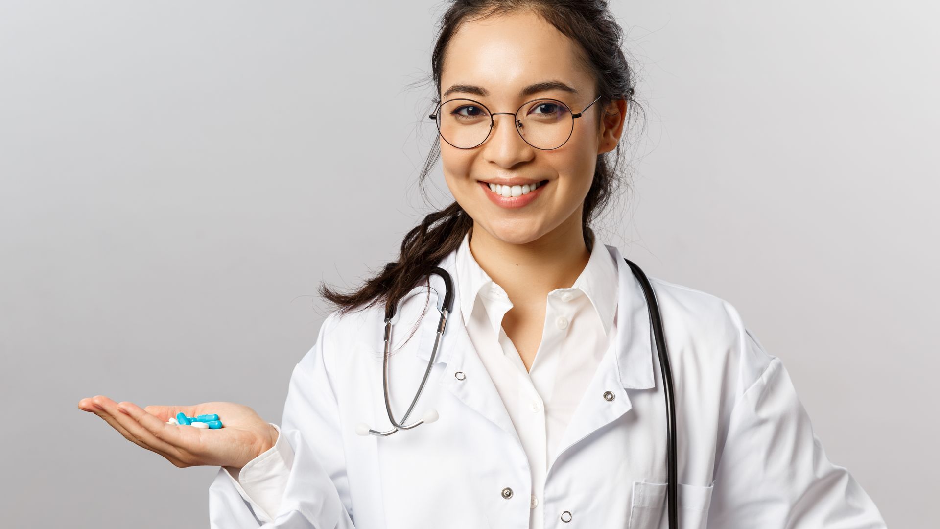 Modafinil First Time User Guide: Your Comprehensive Companion Asian female doctor smiling while holding pills. Promoting healthcare and medicine — modafinil first time user guide