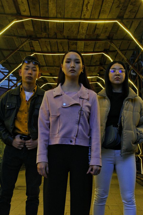 Three friends under a lit underpass at dusk — photo by Zulurid on Pexels