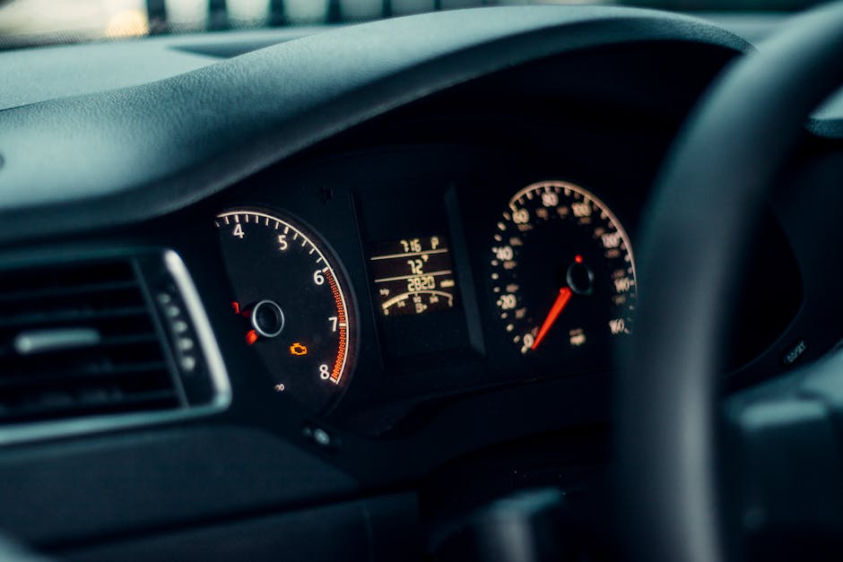 Detailed view of a car's dashboard featuring illuminated gauges and speedometer.