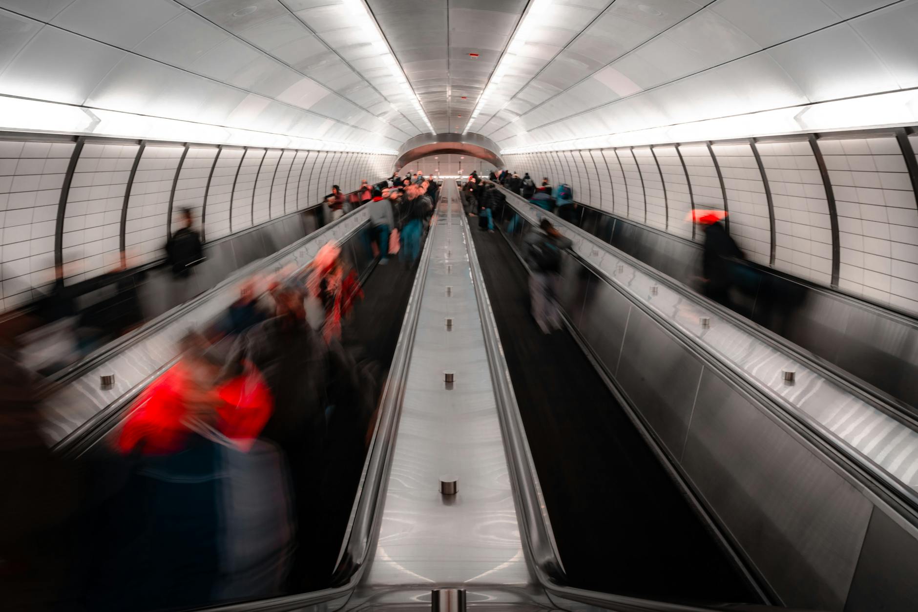 Personas anónimas en una escalera mecánica de un metro moderno